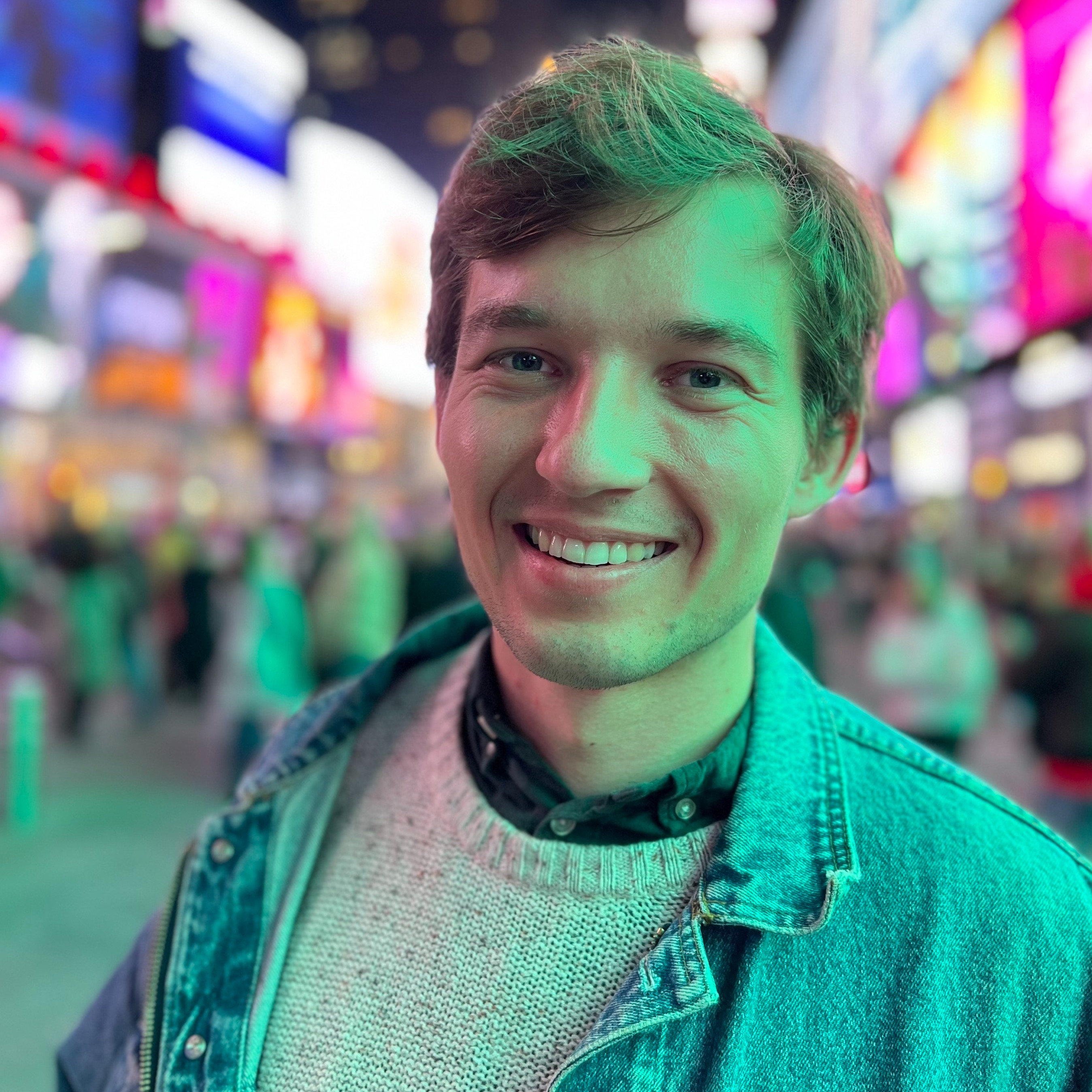 an image of max mynter in colorful artificial lights on timessquare in new york